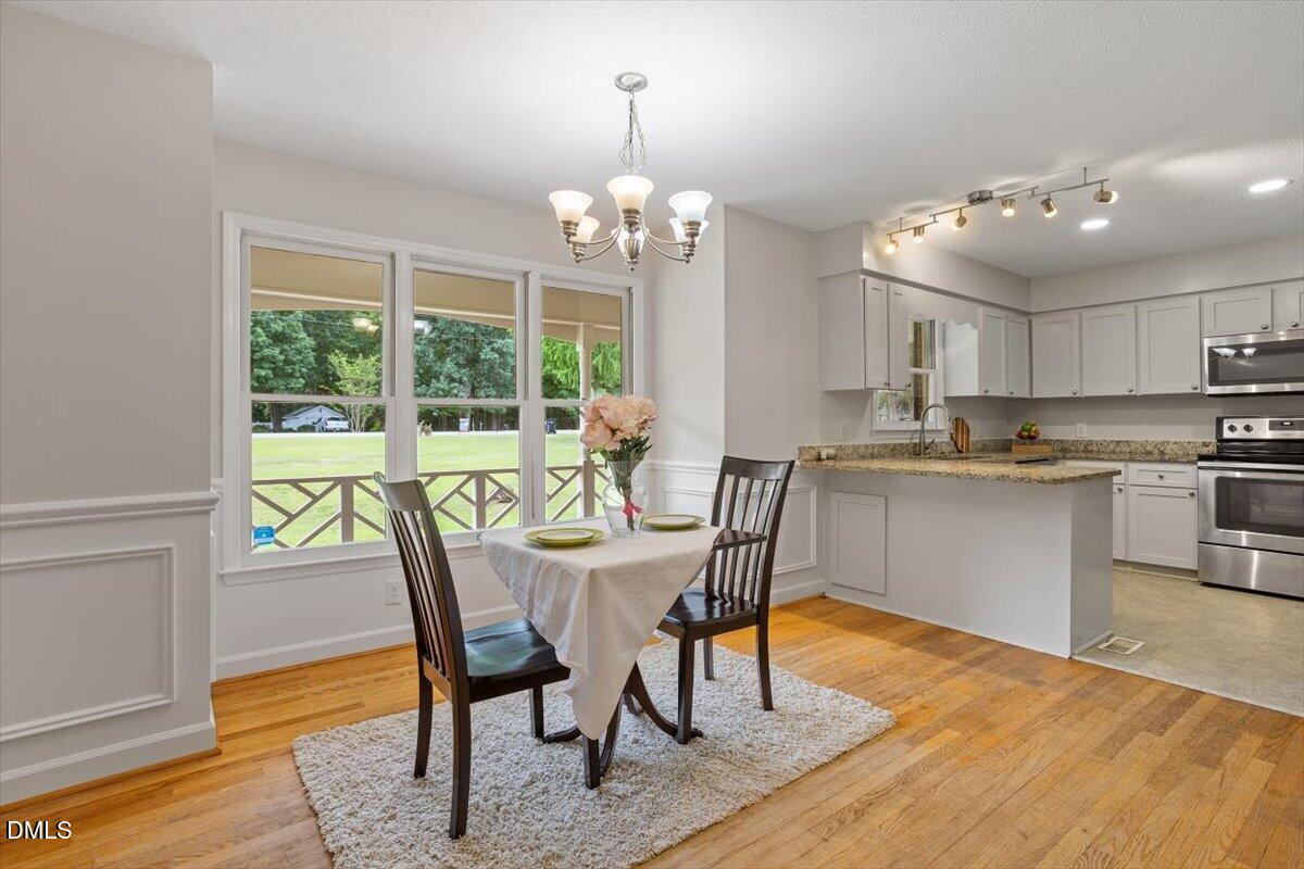 805 Rand Road Garner, NC 27529 - Photo 22 of 38 a view of a dining room with furniture a chandelier and wooden floor