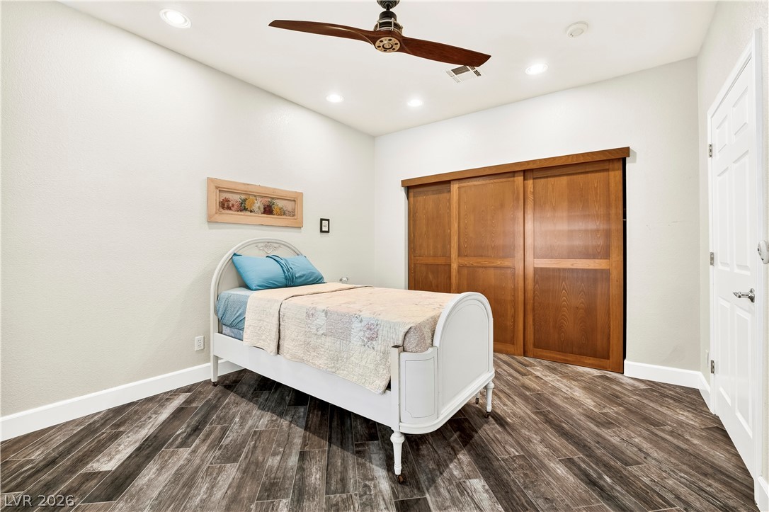 1135 Calico Ridge Drive Henderson, NV 89011 - Photo 26 of 86 Recessed lighting and a classic wood ceiling fan illuminate this inviting downstairs bedroom, featuring rich wood-look porcelain tile flooring and a spacious closet.