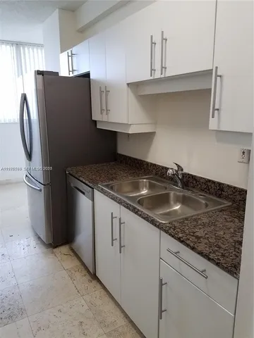 a kitchen with stainless steel appliances granite countertop a refrigerator a sink and a granite counter tops