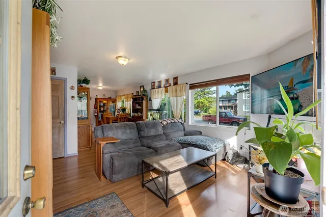 a living room with furniture a flat screen tv and a large window