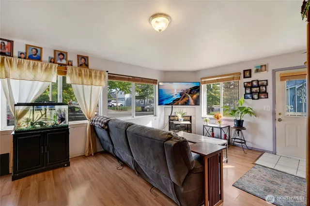 a living room with furniture a bookshelf and a large window