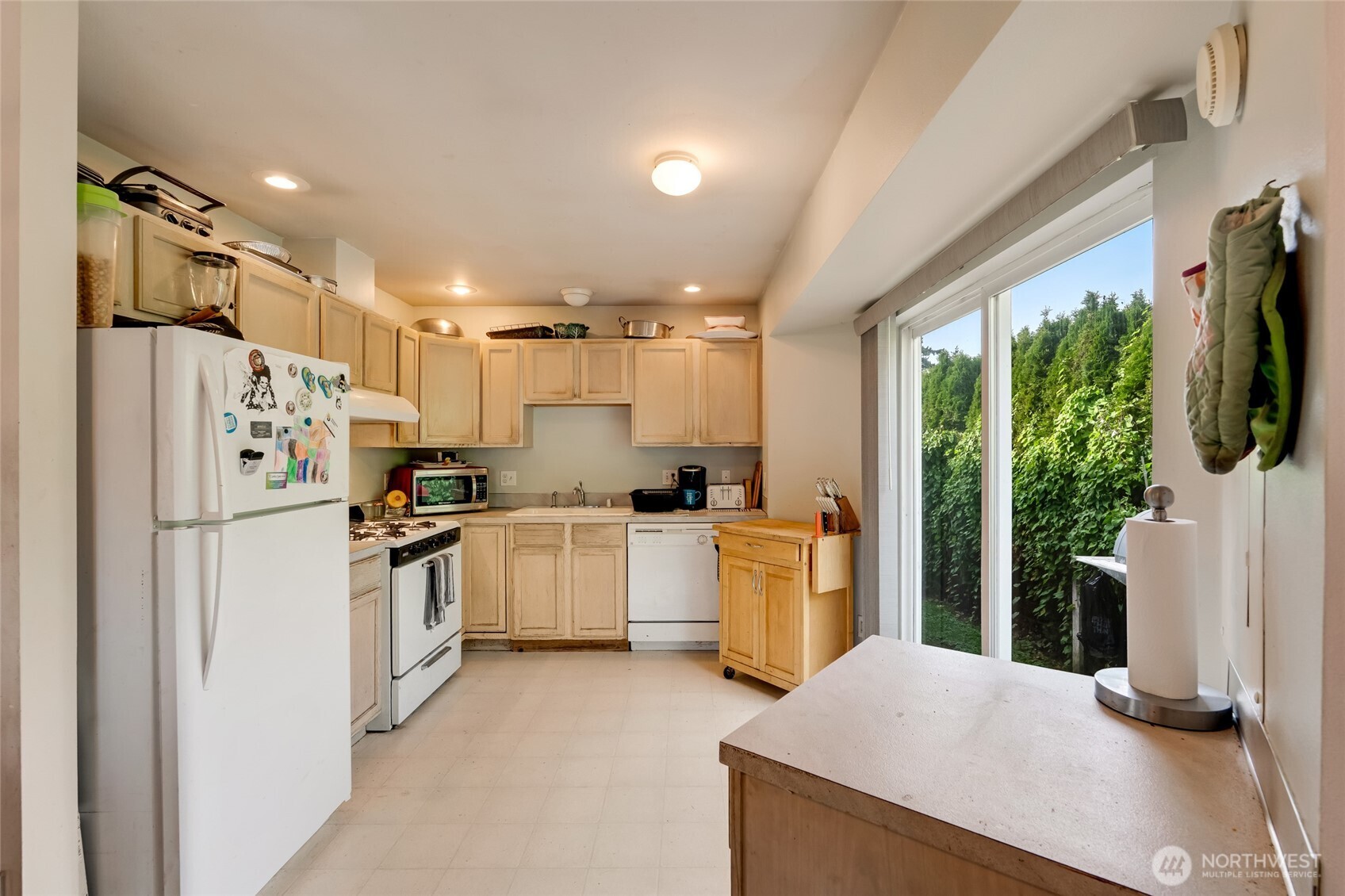 319 6th Street Blaine, WA 98230 - Photo 8 of 24 a kitchen with refrigerator a sink and white cabinets