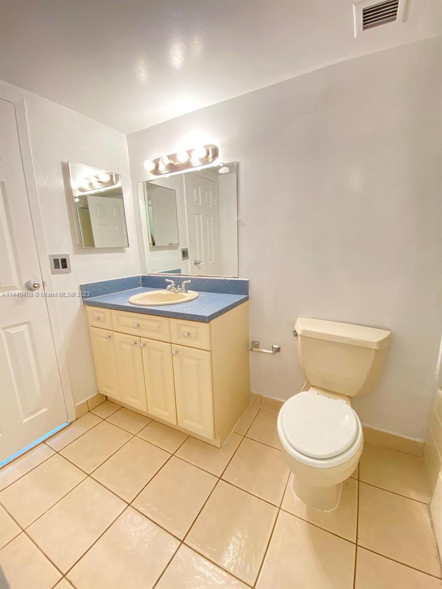 13499 Biscayne Boulevard, Unit 1408 North Miami, FL 33181 - Photo 11 of 24 a bathroom with a sink a toilet and a mirror