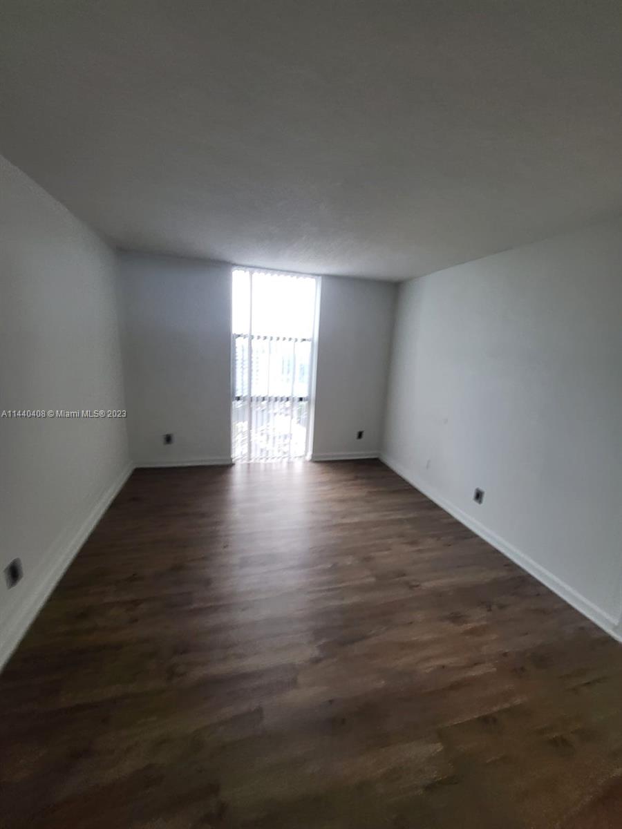 13499 Biscayne Boulevard, Unit 1408 North Miami, FL 33181 - Photo 13 of 24 an empty room with wooden floor and windows