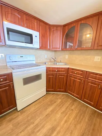 a kitchen with stainless steel appliances granite countertop wooden cabinets a stove a sink and dishwasher