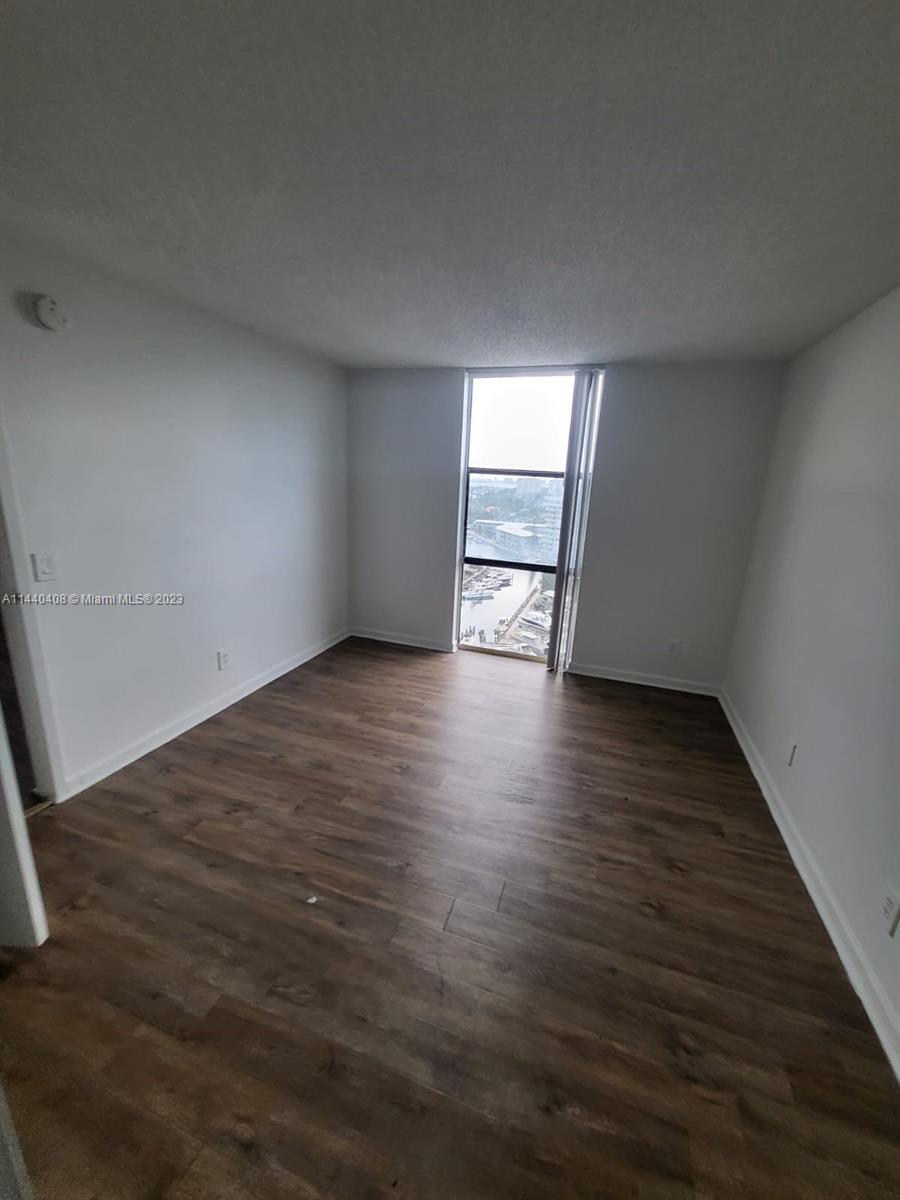 13499 Biscayne Boulevard, Unit 1408 North Miami, FL 33181 - Photo 17 of 24 an empty room with wooden floor and windows