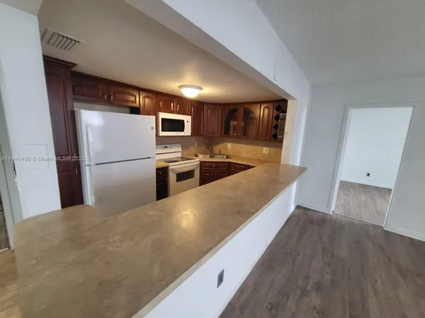 a large kitchen with a refrigerator and a sink