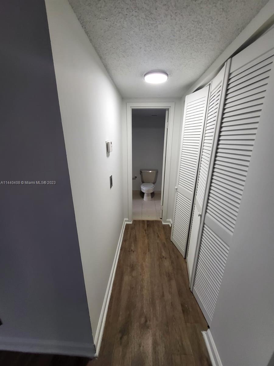 13499 Biscayne Boulevard, Unit 1408 North Miami, FL 33181 - Photo 8 of 24 a view of a hallway with wooden floor and staircase