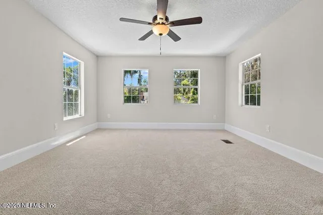 an empty room with window and ceiling fan