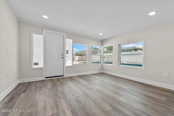 an empty room with wooden floor and a window