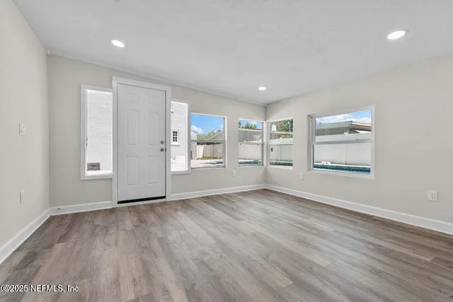 an empty room with wooden floor and a window