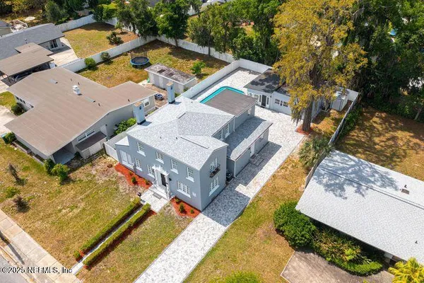 an aerial view of a house with swimming pool and outdoor seating