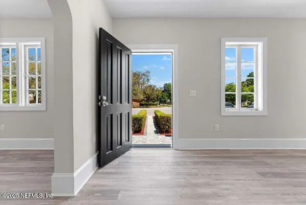 an empty room with windows and a fireplace