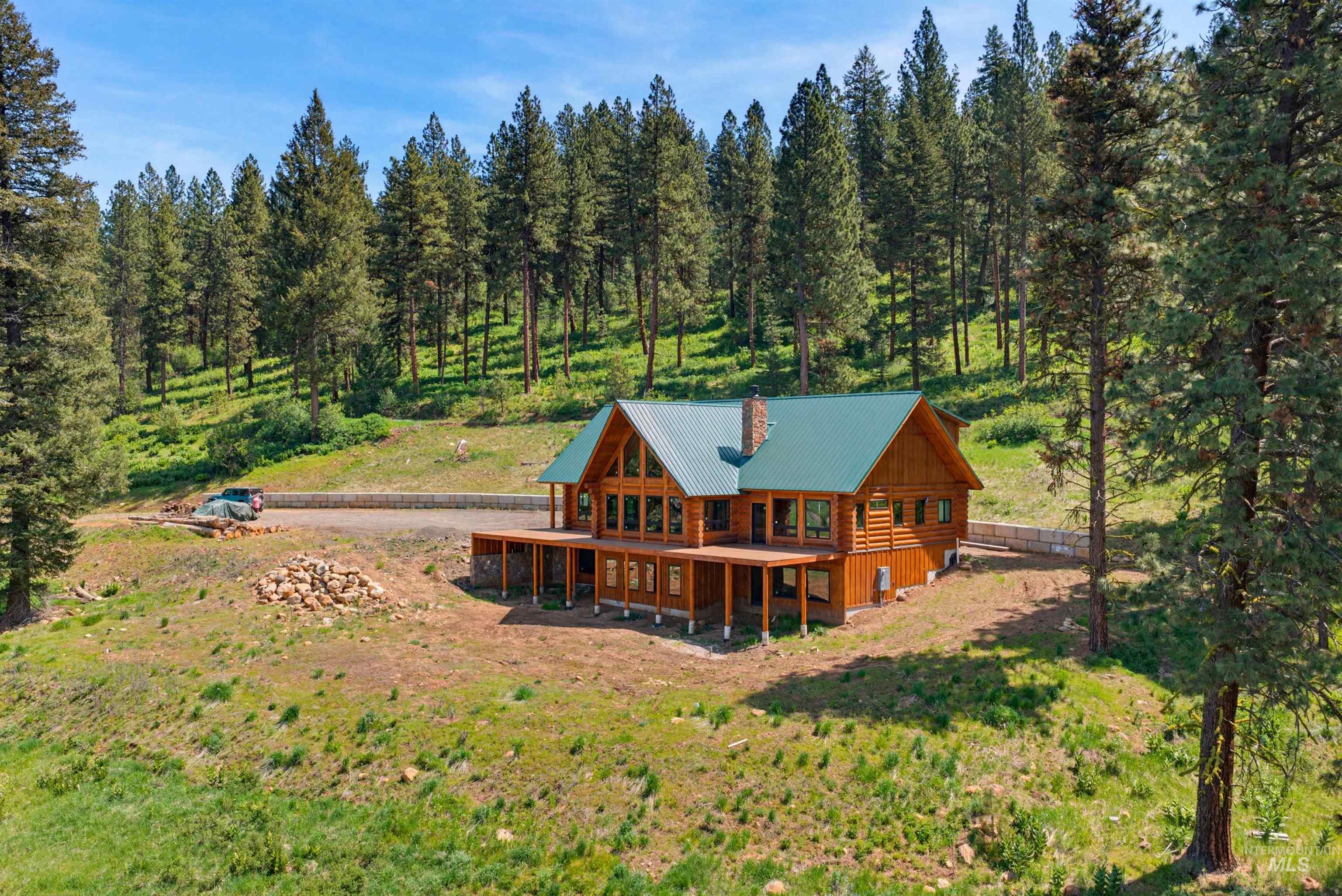 3322 Big Creek Road New Meadows, ID 83654 - Photo 8 of 50 Wood-sided cabin featuring a green metal roof and a stone chimney