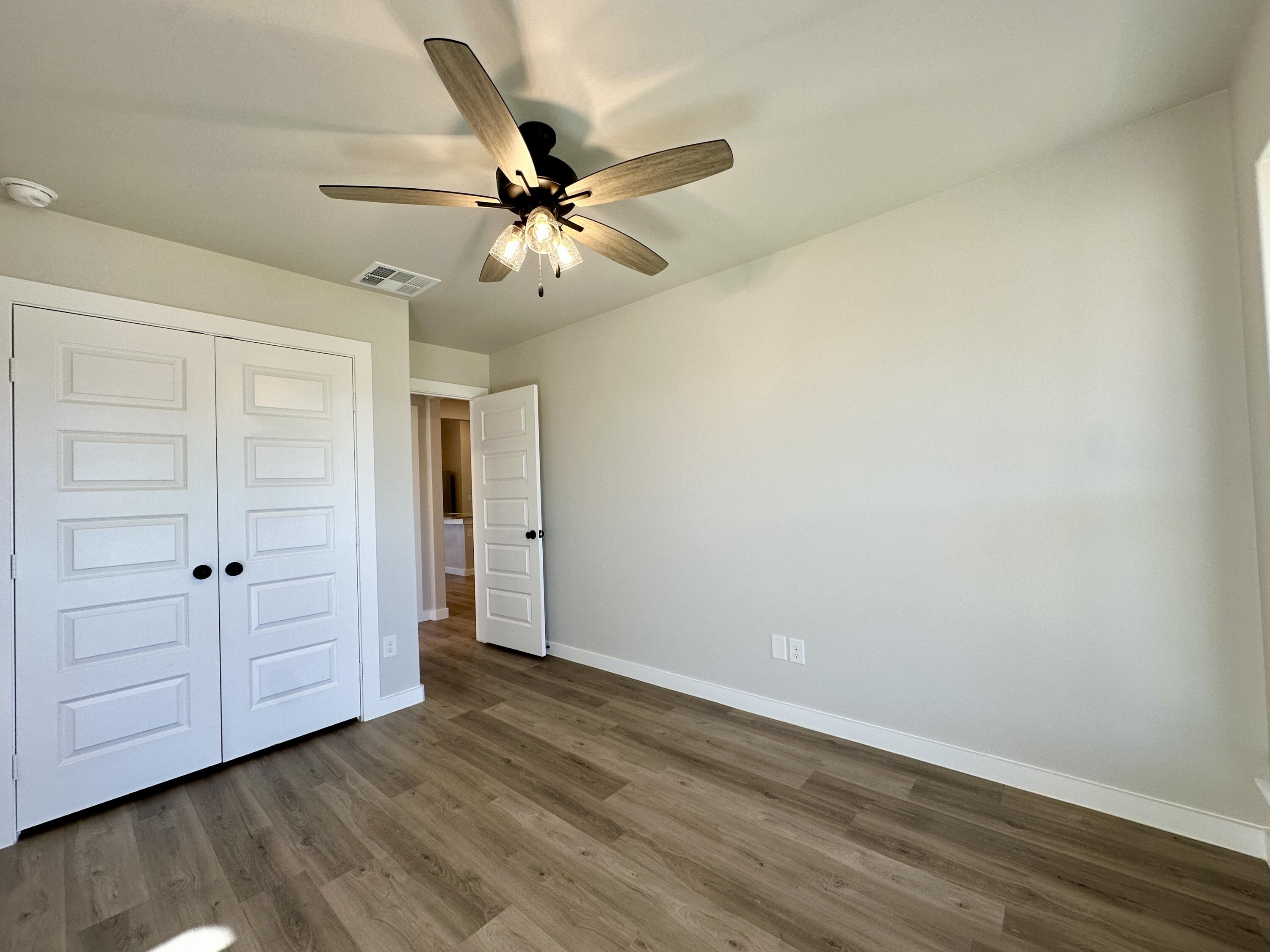 2208 134th Street Lubbock, TX 79423 - Photo 6 of 17 an empty room with wooden floor fan and windows
