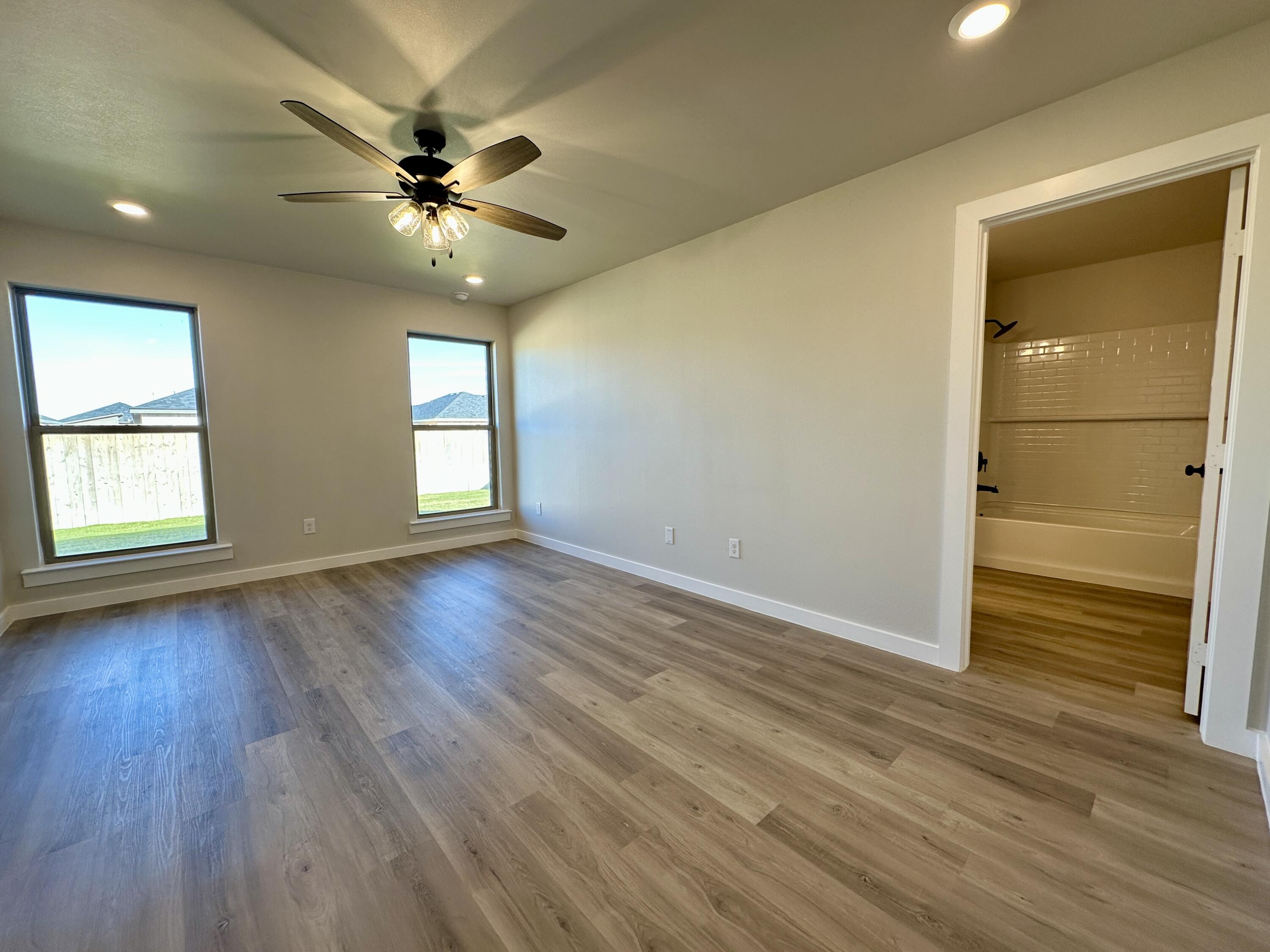 2208 134th Street Lubbock, TX 79423 - Photo 10 of 17 a view of an empty room with wooden floor and a window