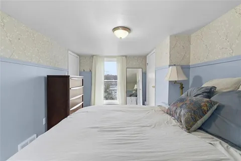 a bedroom with a bed and a refrigerator