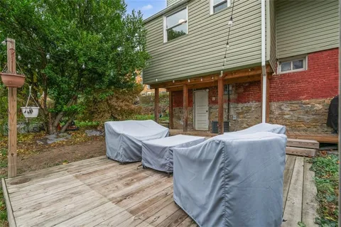 a view of a patio with table and chairs with wooden floor and fence