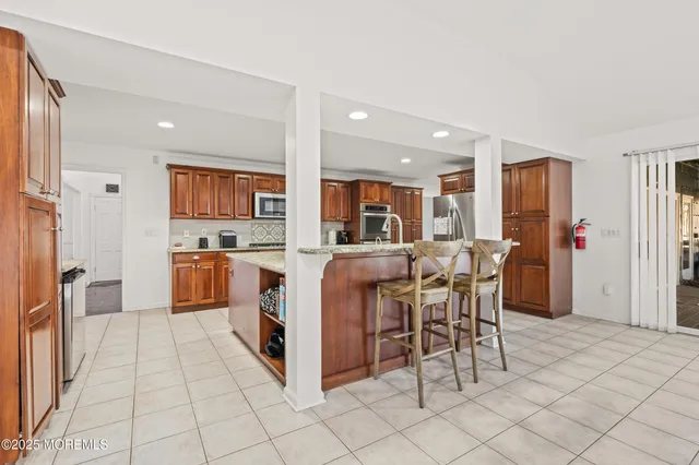 a open kitchen with stainless steel appliances kitchen island granite countertop a refrigerator and cabinets