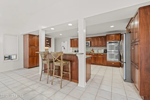 a kitchen with stainless steel appliances granite countertop a refrigerator and a sink