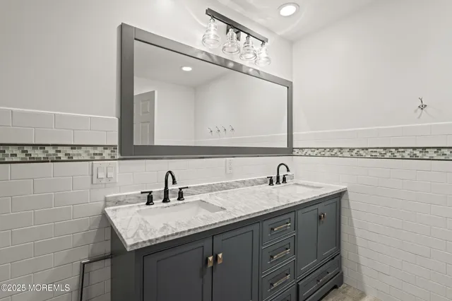 a bathroom with a granite countertop sink a large mirror and