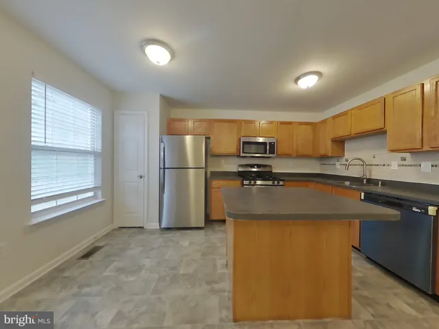 a kitchen with stainless steel appliances granite countertop a refrigerator a stove a sink dishwasher and a refrigerator