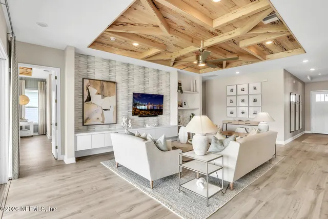 a living room with furniture a flat screen tv and a table