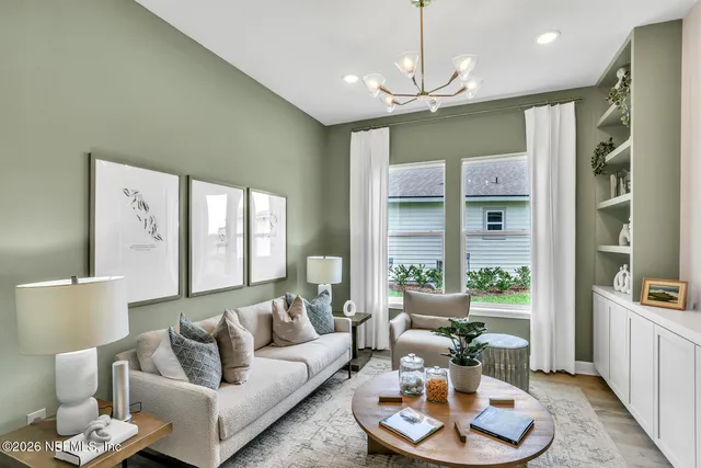 a living room with furniture kitchen and a chandelier