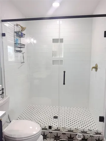 a bathroom with a toilet and a shower
