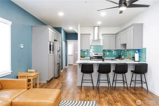 a living room with stainless steel appliances granite countertop furniture a rug kitchen view and a chandelier