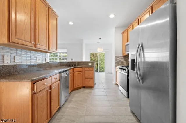 a kitchen with stainless steel appliances granite countertop a refrigerator and a sink