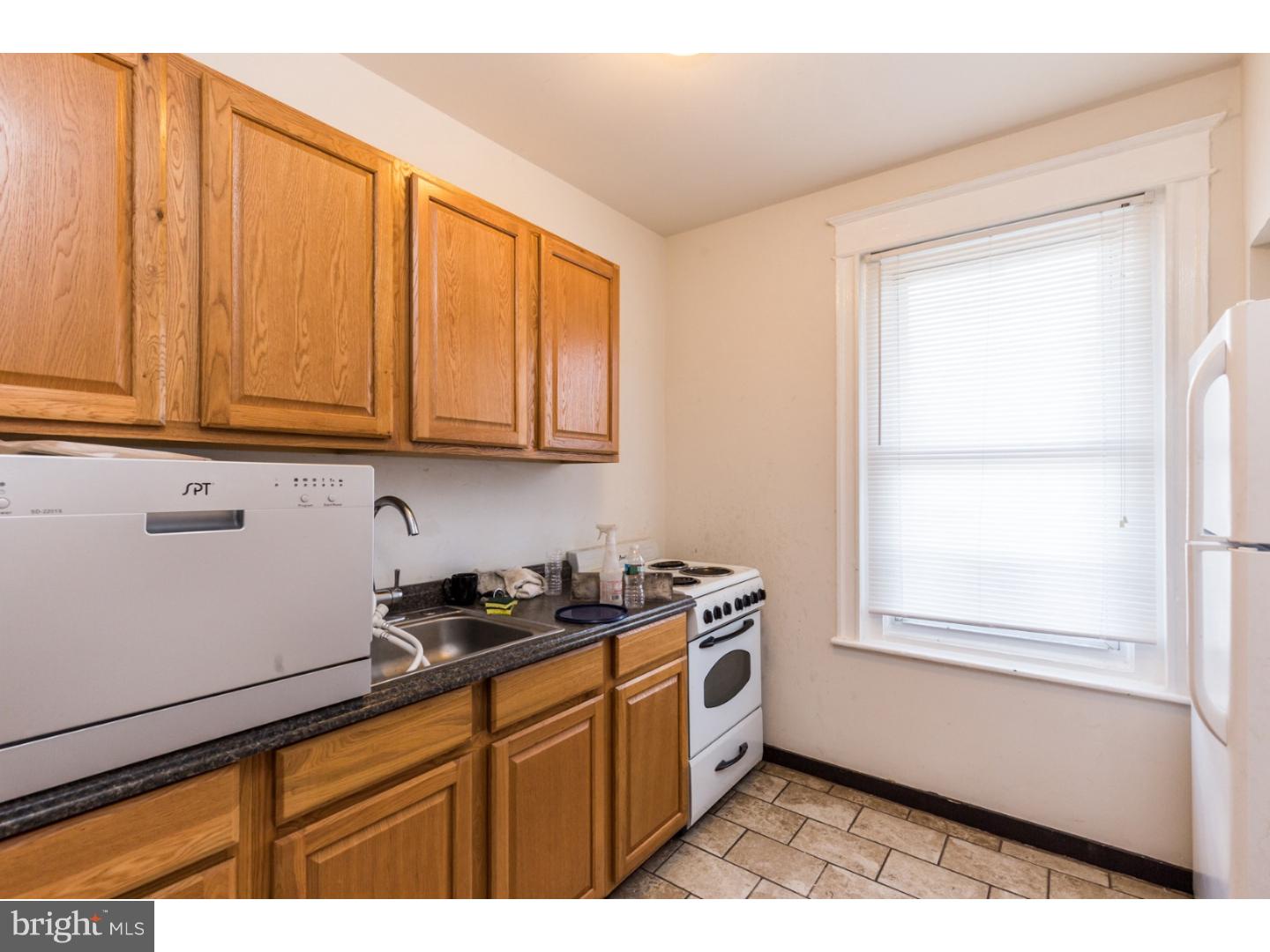 5013 Chester Avenue, Unit 3 Philadelphia, PA 19143 - Photo 12 of 17 a kitchen with stainless steel appliances granite countertop a sink cabinets and a window