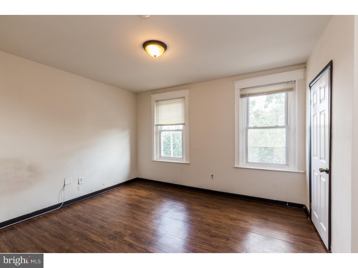 5013 Chester Avenue, Unit 3 Philadelphia, PA 19143 - Photo 15 of 17 an empty room with wooden floor and windows
