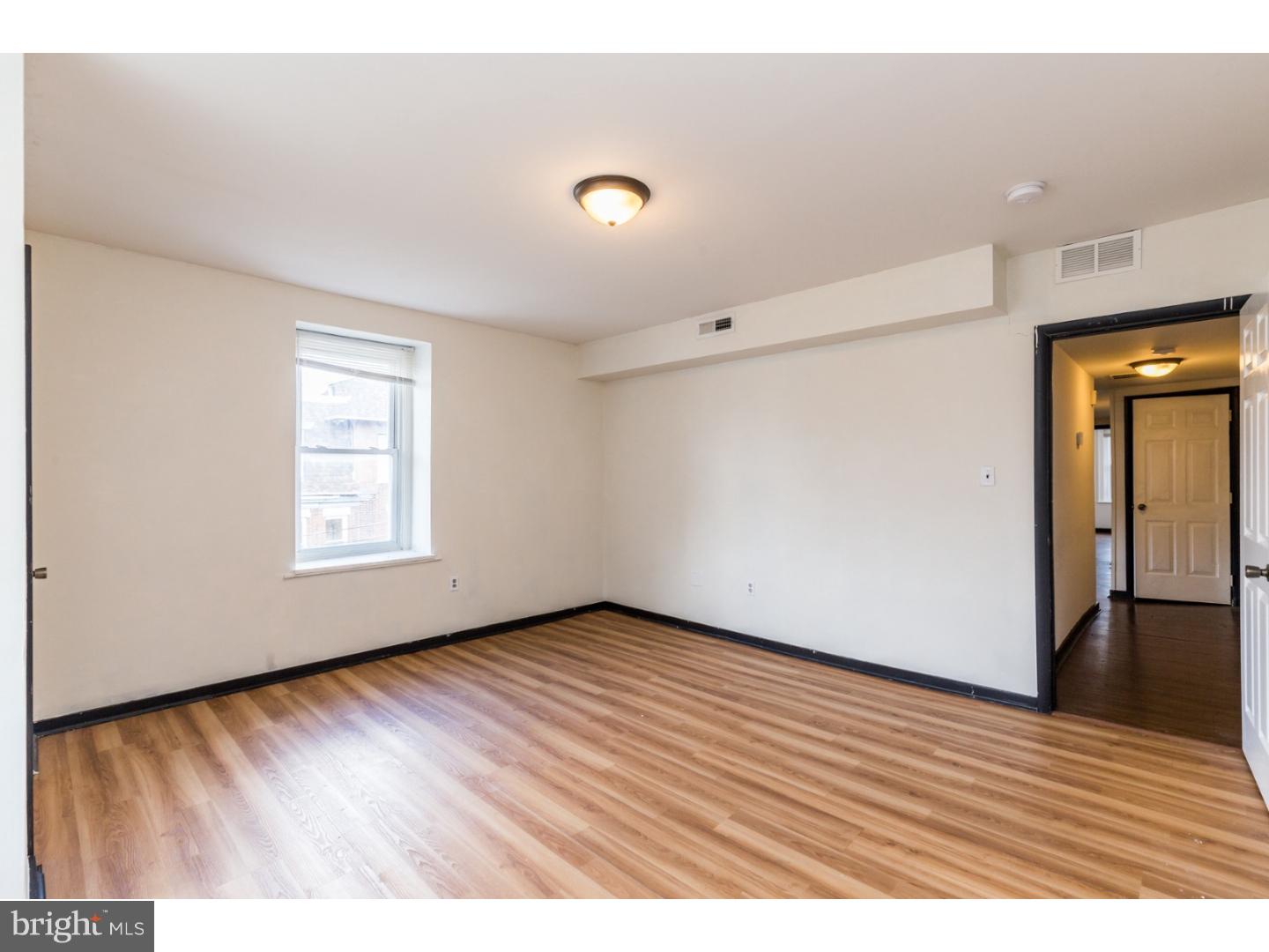 5013 Chester Avenue, Unit 3 Philadelphia, PA 19143 - Photo 5 of 17 a view of an empty room with wooden floor and a window