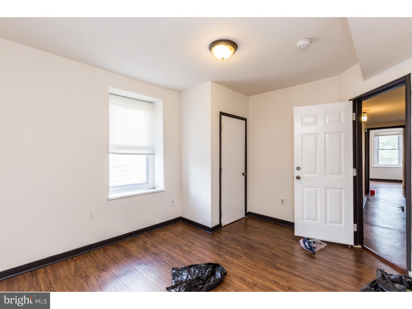 5013 Chester Avenue, Unit 3 Philadelphia, PA 19143 - Photo 7 of 17 an empty room with wooden floor and windows