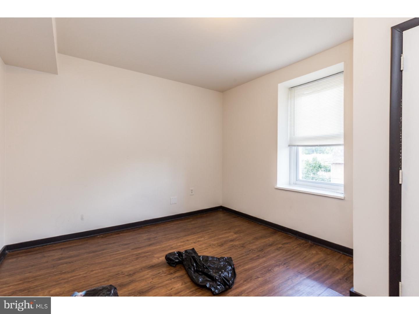 5013 Chester Avenue, Unit 3 Philadelphia, PA 19143 - Photo 8 of 17 an empty room with wooden floor and windows