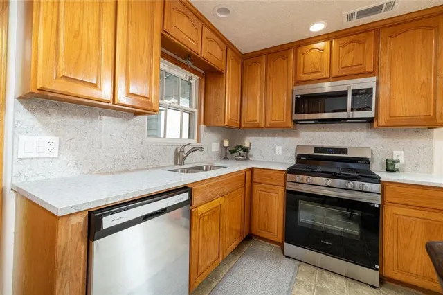 a kitchen with a sink cabinets and a window