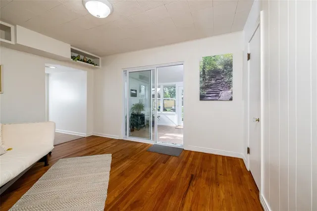 a view of a livingroom with wooden floor and a bathroom