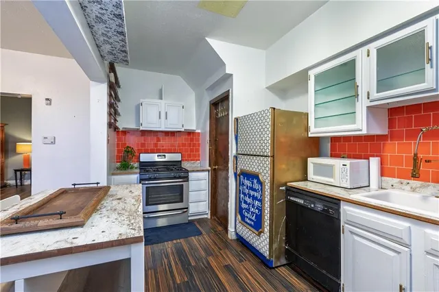 a kitchen with stainless steel appliances granite countertop a stove refrigerator and microwave