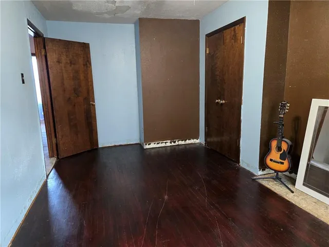 an empty room with wooden floor and mirror
