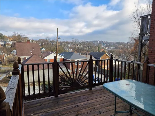 a view of a balcony with wooden floor and outdoor seating
