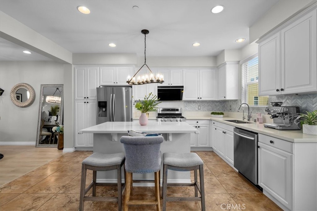 5565 Ocean, Unit 103 Hawthorne, CA 90250 - Photo 14 of 56 a kitchen with kitchen island stainless steel appliances a dining table and chairs