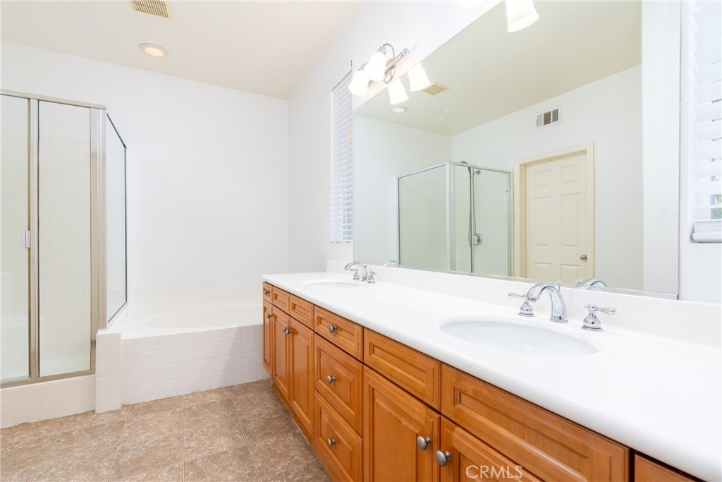 63 Nightshade Irvine, CA 92603 - Photo 9 of 15 a bathroom with a double vanity sink a large mirror and a bathtub