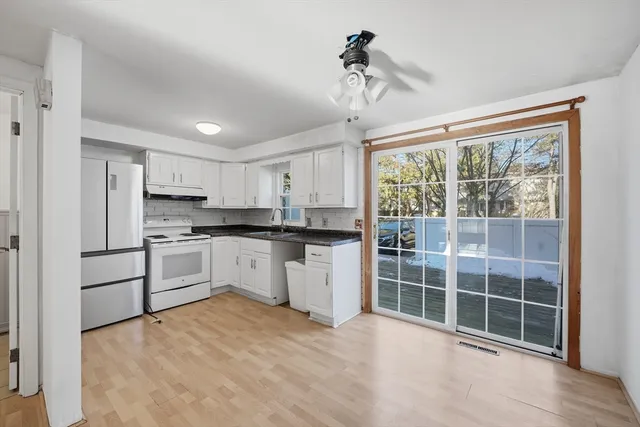 a kitchen with white cabinets and white appliances