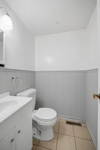 a bathroom with a toilet a sink and vanity