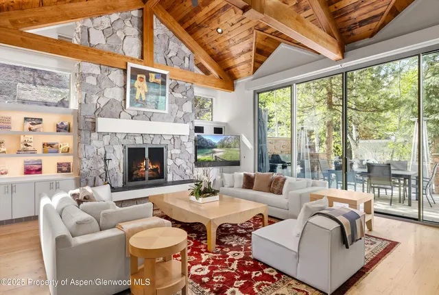 a living room with furniture a fireplace and a large window