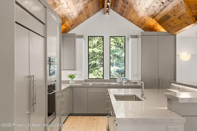 a bedroom with a large bed and large windows