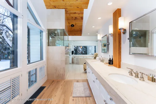 a bathroom with a tub a sink and a large window