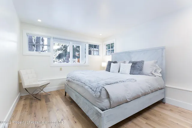 a bedroom with a bed and a lamp on dresser