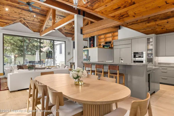 a dining room with furniture a chandelier and wooden floor